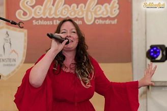 Entertainerin Nicole Trunt singt im roten Kleid auf der Festzeltbühne